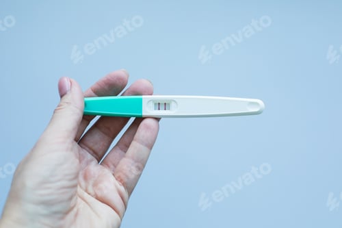 Preview: Pregnancy test with positive pregnan in woman's hand. Copy space.