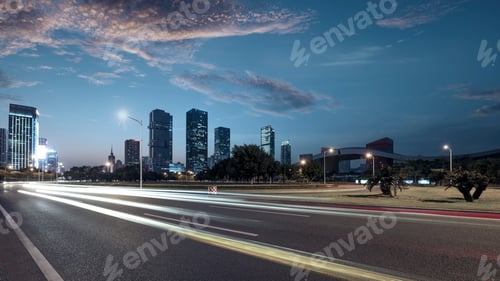 Cityscape at Night with Light Trails on Road