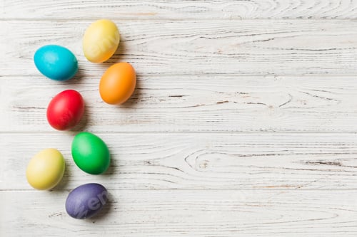 Preview: Brightly Colored Easter Eggs on White Wood Surface