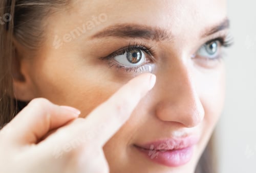 Preview: Young lady wearing contact eye lenses, close up