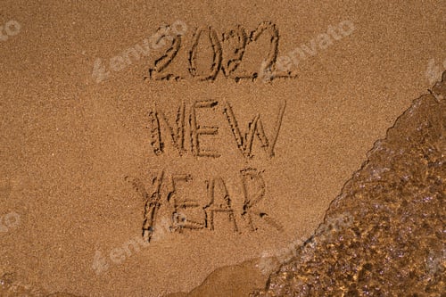 Preview: 2022 is drawing on sand on a beach with a wave by the sea. Vacation on the sea. New Year concept