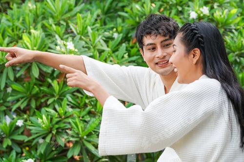Preview: Asian couple in hotel bathrobe talking at balcony