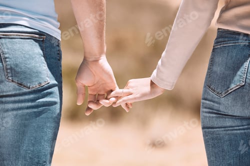 Preview: Affectionate couple holding hands showing love, caring and bonding outside together in nature. Lov