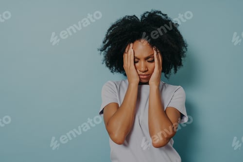 Preview: Tired stressed young african woman sighing from tiredness or suffering from headache