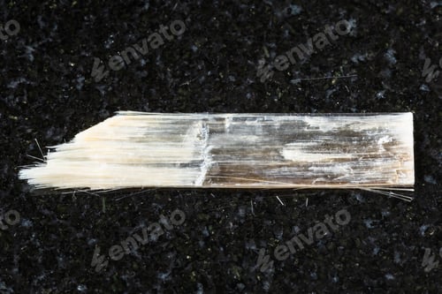 Preview: sample of rough nemalite mineral on black granite