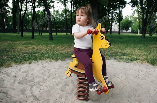Preview: A little girl rides a horse on a spring in the park. Lifestyle. Copy space.