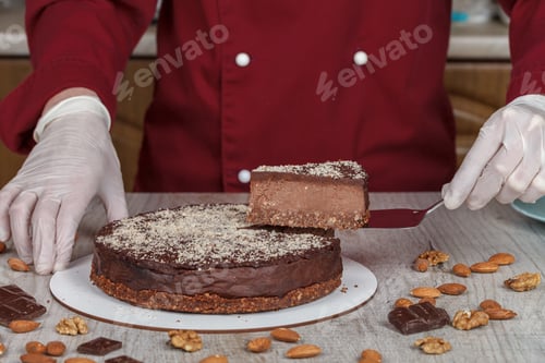 Preview: Chocolate cake with a cut piece and blade on gray background, closeup