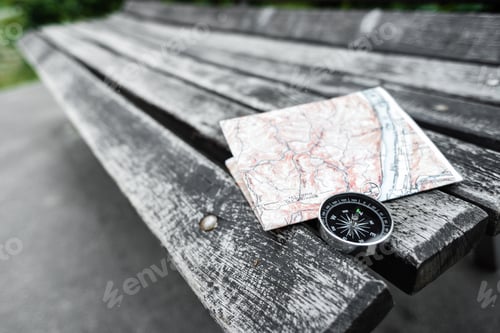 Preview: Compass and map on a beautiful wooden surface. Top view