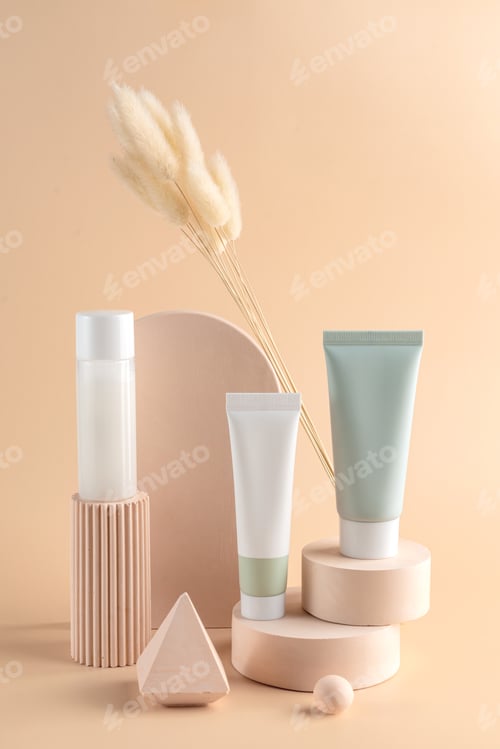 Preview: Group of white and green blank, unbranded cosmetic cream tubes and toner bottle on beige background.
