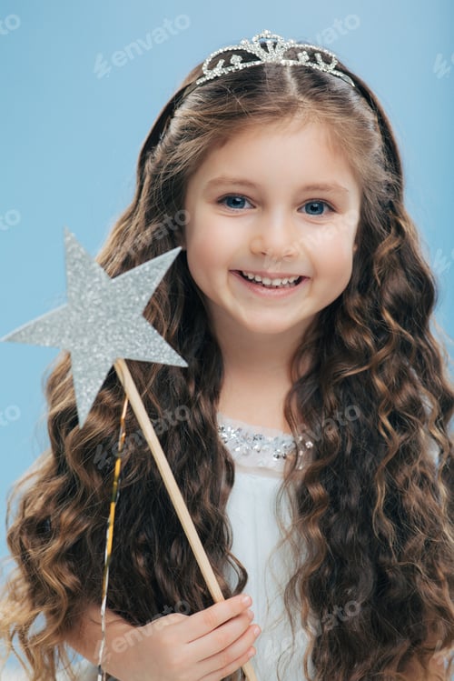 Preview: Cute little girl with positive expression, holds wand, has curly dark hair, carries wand