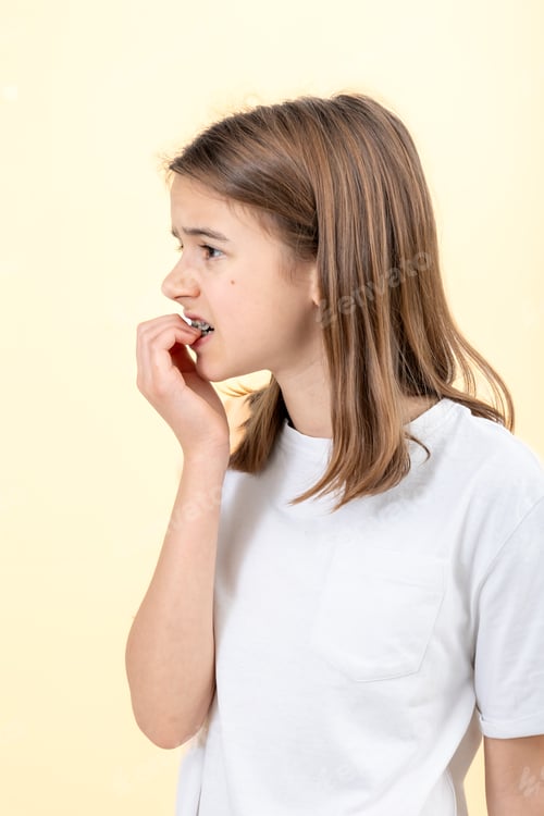 Preview: Scared and anxious girl, biting her fingernails on a white background isolated.