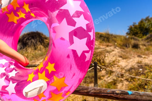 Preview: Inflatable round float of pink childish colors on the way to the beach.