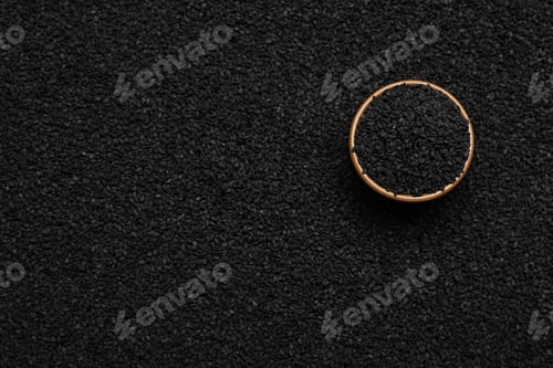 Preview: Bowl on pile of black sesame seeds, top view. Space for text