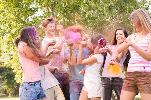 Preview: Happy friends covered in powder paint on a sunny day