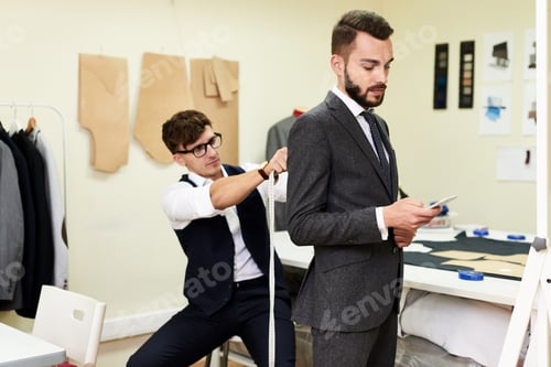 Preview: Tailor Fitting Handsome Businessman for Bespoke Suit