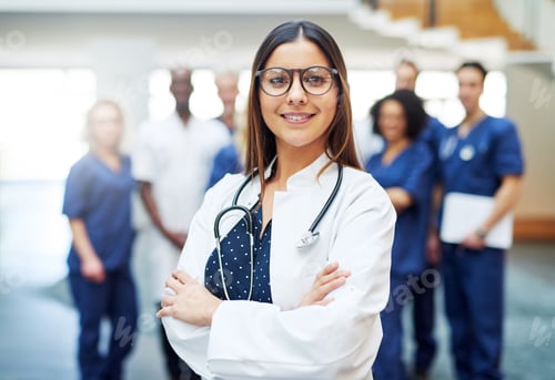 Preview: Young pretty female doctor standing in clinic