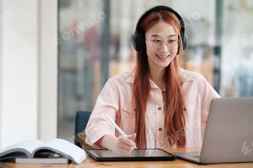 Preview: Young collage student using computer and mobile device studying online.
