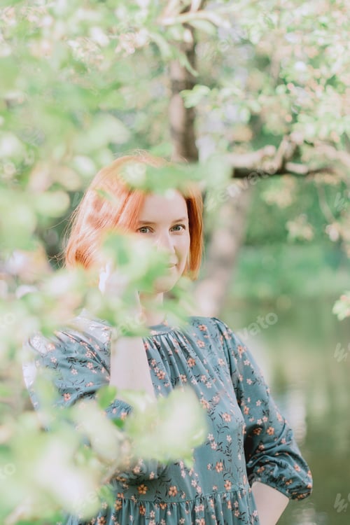 Preview: Young redhaired beautiful woman wear casual dress walking in spring park.