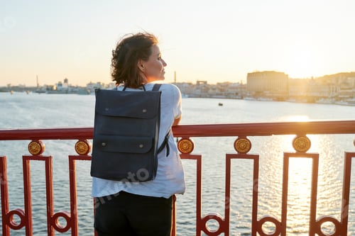Preview: Woman with backpack standing with backpack on the bridge