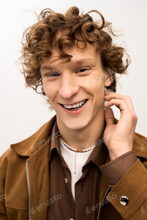 Preview: Handsome young man smiles brightly while dressed in stylish attire in a modern setting