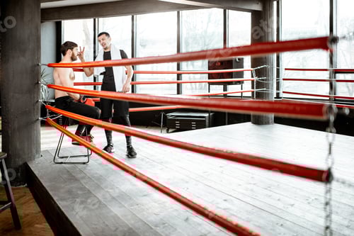 Preview: Boxing trainer with boxer on the boxing ring