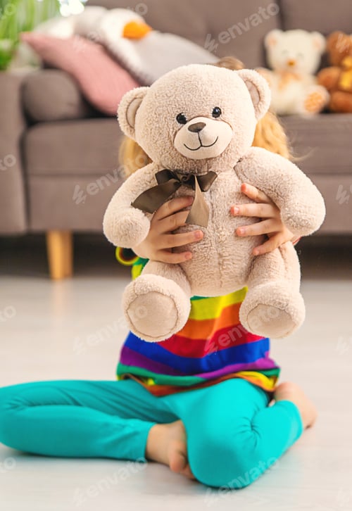 Preview: Child loves teddy bear at home. Selective focus.