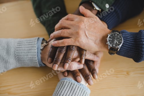 Preview: cropped shot of friends making team gesture with hands
