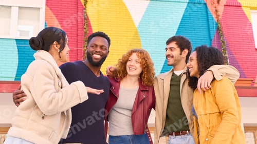 Preview: Group of multiethnic young people smiling and having fun in front of colorful wall