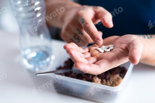 Preview: Close up of pills in hands of a professional strongman