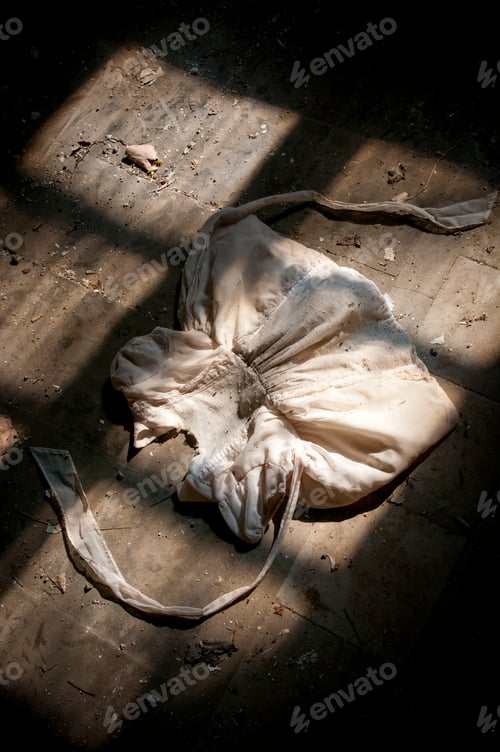 Preview: Old dirty white kids clothe on the ground with bright light entering the window