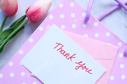 Preview: thank you message on sticky note with tulip flower on pink background