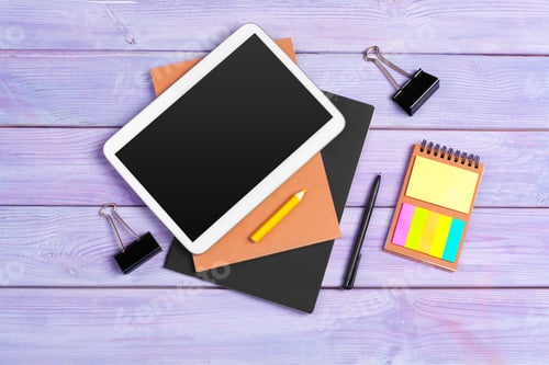 Preview: Digital tablet and notepad office on purple wooden background