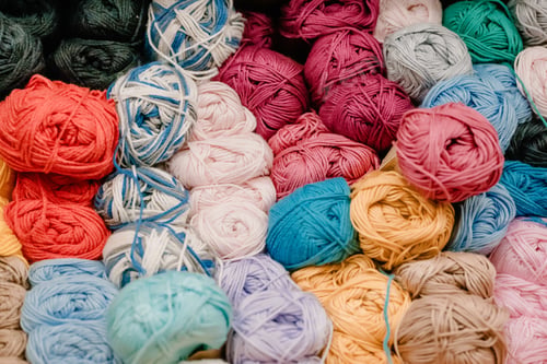 Preview: Different colored yarn balls in the shop. Multi-colored Yarn for knitting on shelf in store