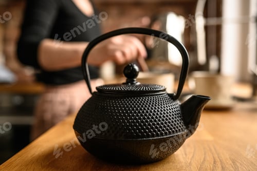 Preview: Black metal teapot with hot tea at the kitchen