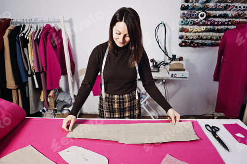 Preview: Female fashion designer tailor making sewing patterns at workplace in sewing studio