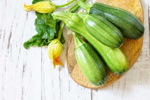 Preview: Fresh healthy green zucchini on a wooden kitchen table.