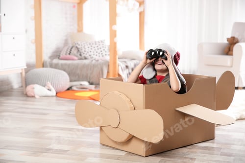 Preview: Cute little boy playing with binoculars and cardboard airplane in bedroom