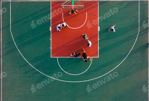 Preview: Aerial view of people playing a game of basketball on an outdoor court
