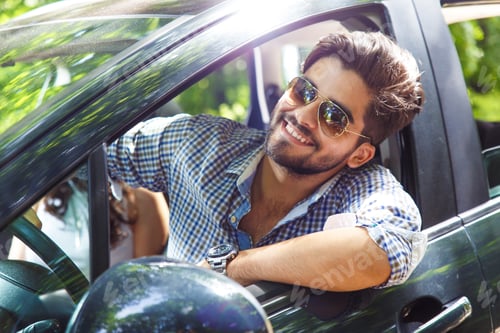 Preview: Portrait of young man in car looking out the window.