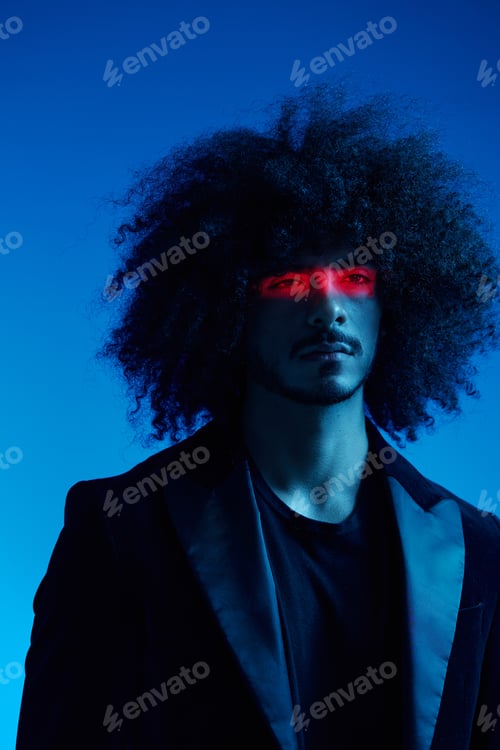 Preview: Fashion portrait of a man with curly hair on a blue background with a red stripe of light