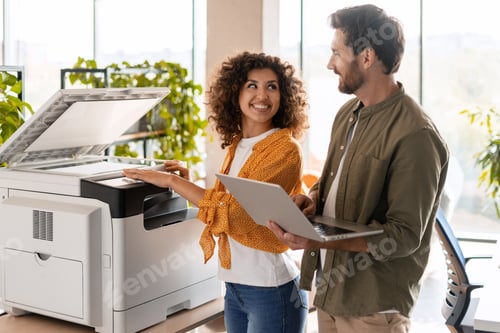 Preview: Business partners using printer and laptop in office