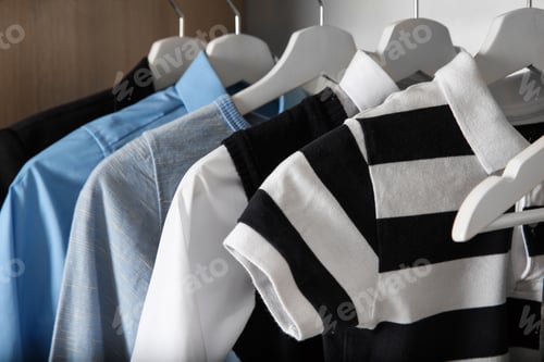 Preview: Stylish boy's clothes hanging in wardrobe, closeup