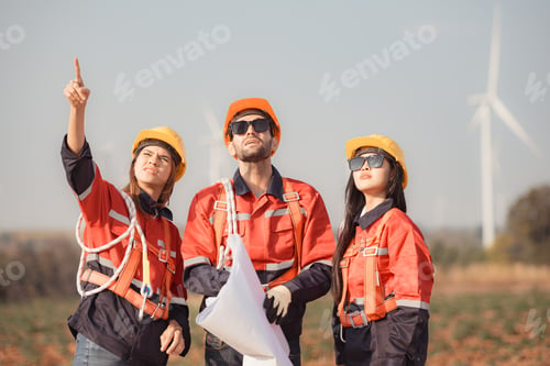 Preview: Team of engineers and architects working on wind turbines in a wind farm
