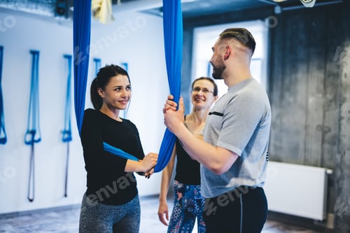 Preview: Aerial yoga couple training in hammock with instructor