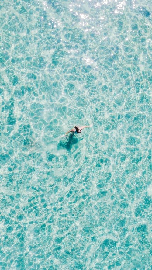 Preview: Mesmerizing aerial top view of woman swimming in the sea