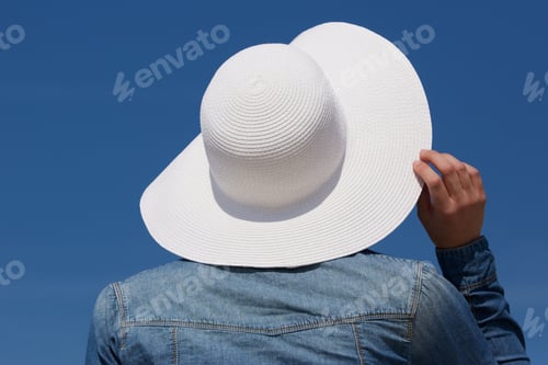 Preview: Back of a young woman with sun hat
