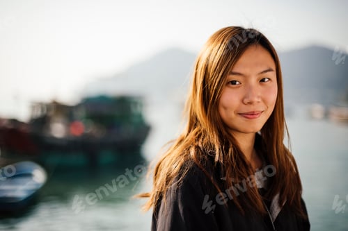 Preview: Portrait of mid adult woman in front of boats on water, looking at camera smiling