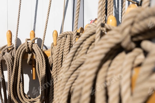 Preview: Closeup shot of the ropes tied on the wooden cleats on a sailing boat