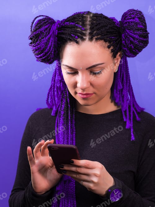Preview: Adorable hipster caucasian female with african colorful braids hairstyle checking news feed or