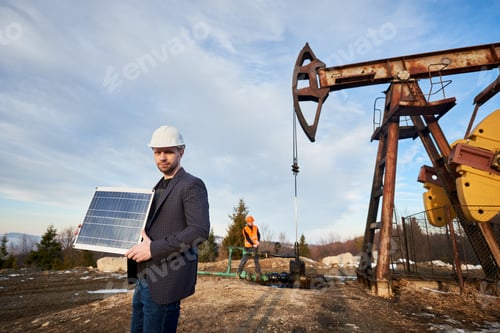 Vista previa: Trabajador petrolero en casco con panel solar.